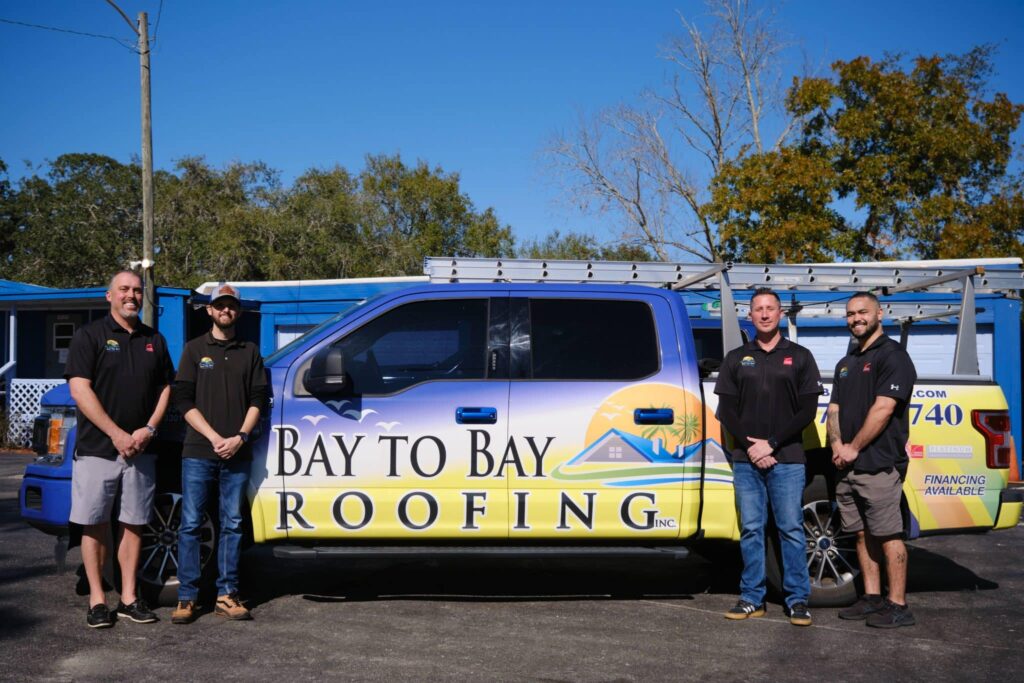 Bay to Bay Roofing team beside a wrapped company truck