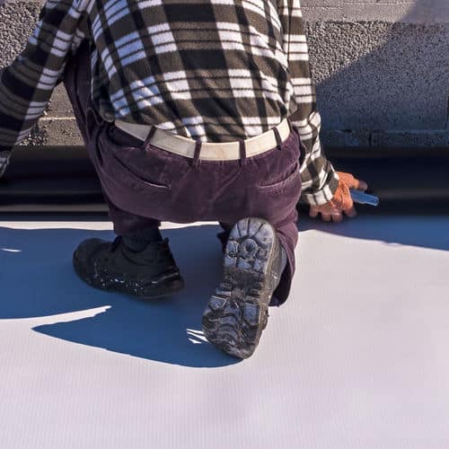 Roofer installs PVC.