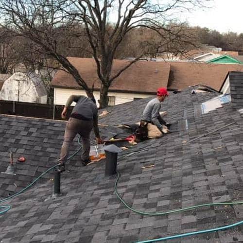 Roofers repair wind damage.