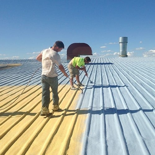 Contractors work on commerical roof coating.