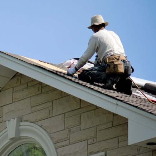 Roofer installs shingles.