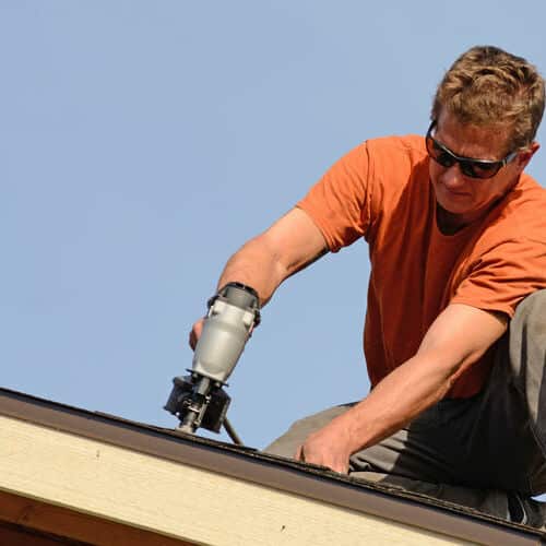 Residential roofer repairs shingles. 