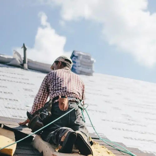 Roofer installs shingles
