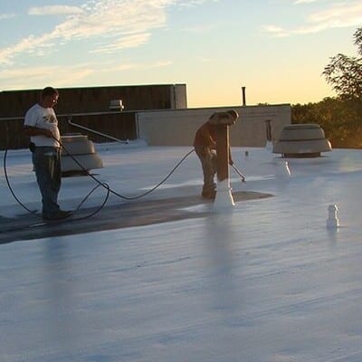 Contractors apply rubber roof coating.