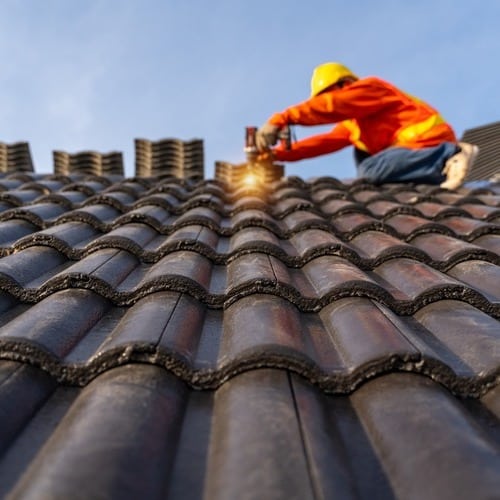 Roofer installs tile roofing.